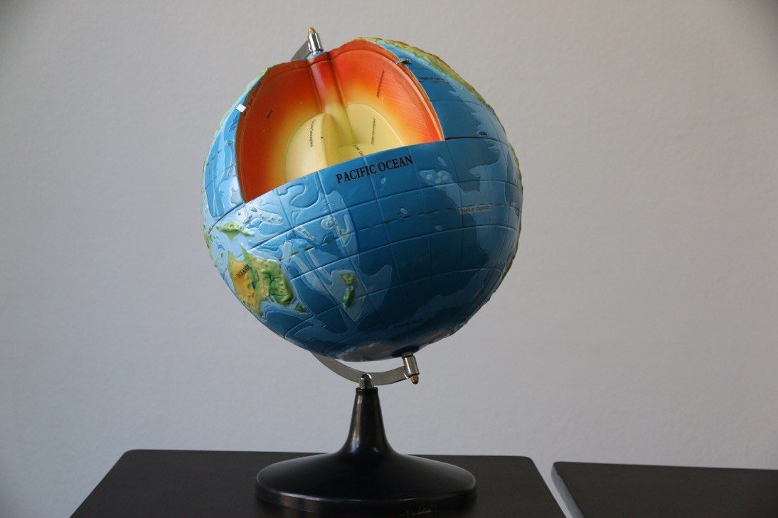 Globo terráqueo seccionado que muestra las capas internas de la Tierra, material didáctico de geografía