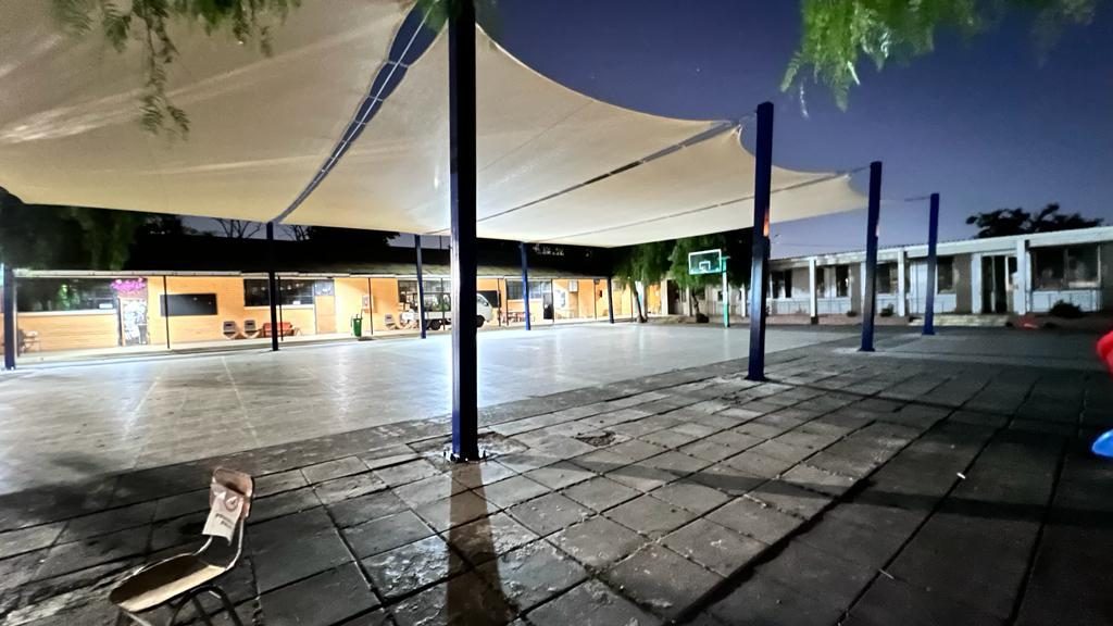 Velas de sombra sobre el patio de un colegio iluminado de noche