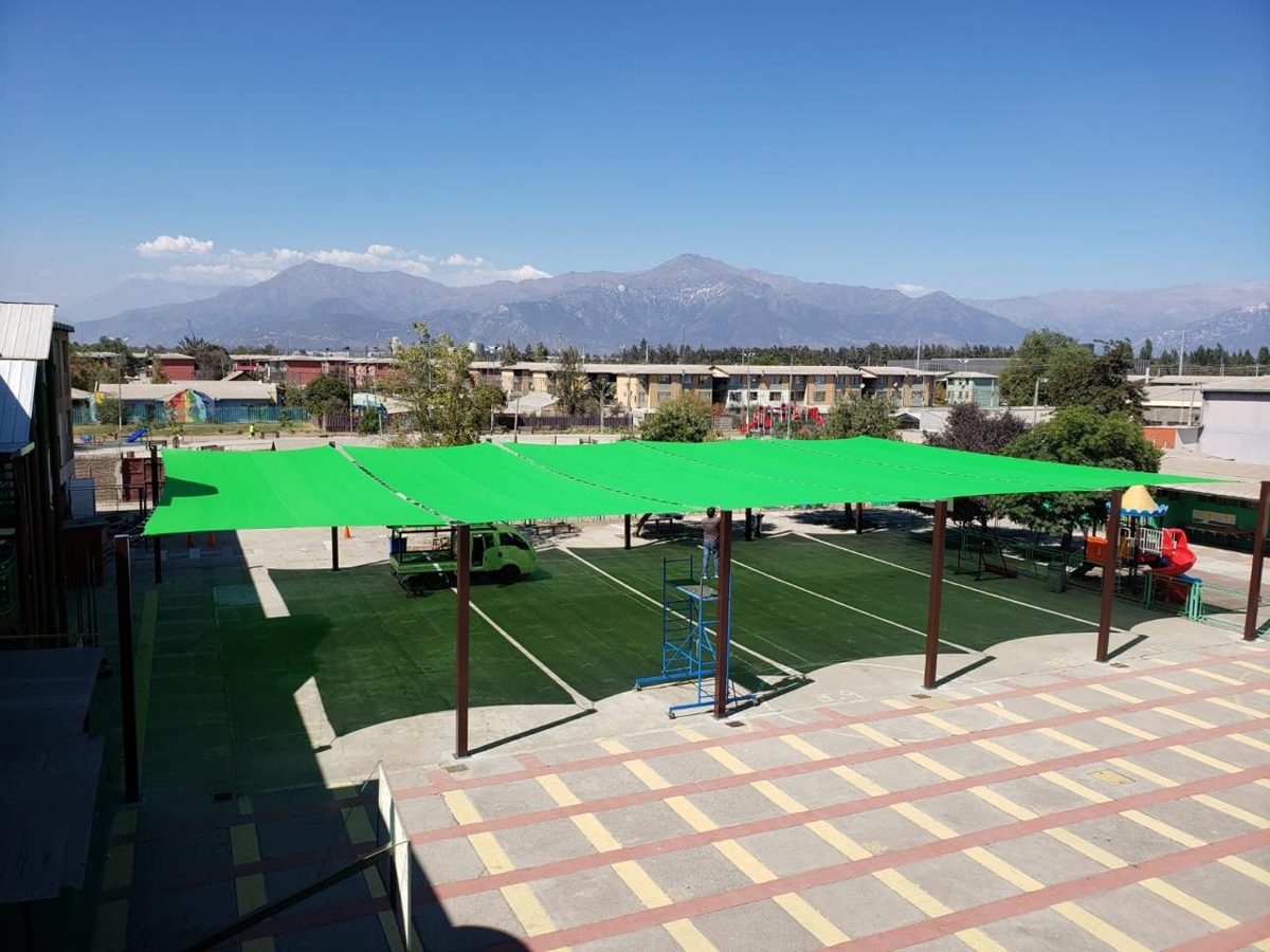 Velas de sombra verdes cubriendo el patio de un colegio con la cordillera de fondo